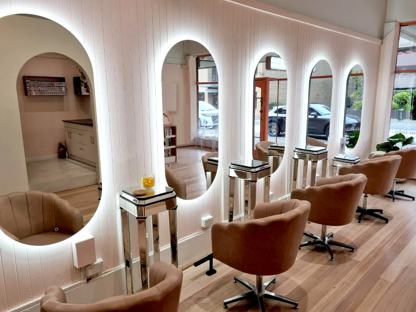Seri Hair+Beauty salon interior — backlit arched mirrors, tan velvet chairs, Camberwell